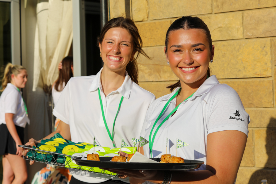 Two hospitality students holding trays of food at SMASH Hospitality event